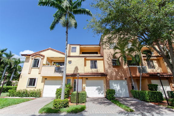Front view of a multi-story house with a garage and balconies.