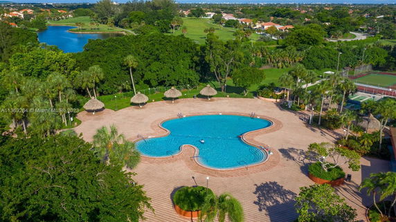 Outdoor swimming pool area surrounded by trees and greenery.