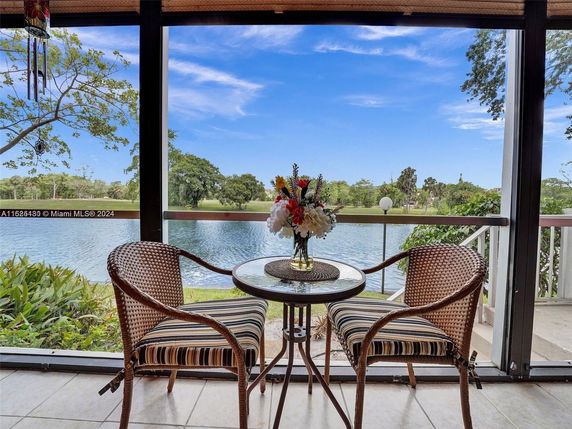 View from a patio overlooking a lake and surrounding trees.