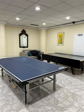 Indoor recreational room with table tennis and air hockey table.