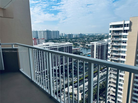 View from a high-rise balcony overlooking surrounding buildings and cityscape.