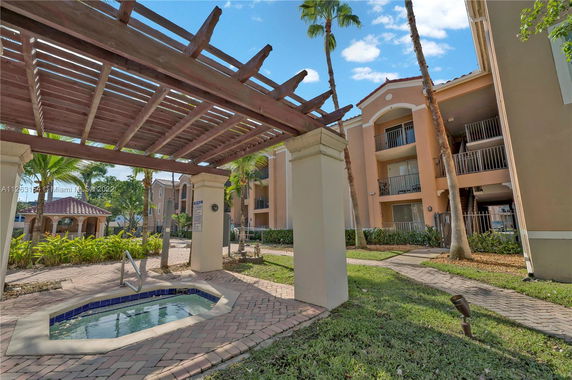 View of a multi-story residential building complex with outdoor landscaping.