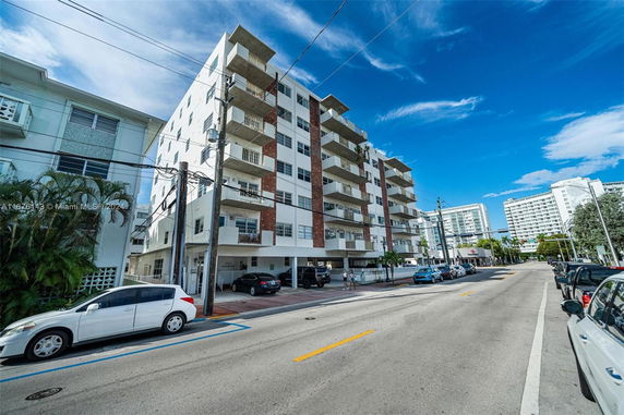 Front view of a multi-story apartment building with balconies.