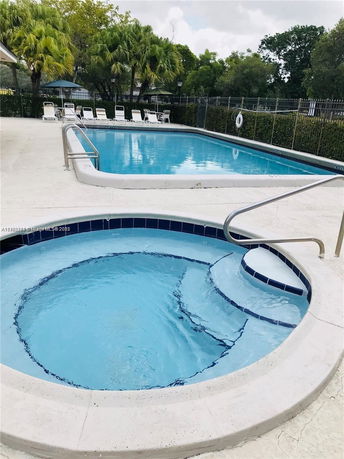 Outdoor swimming pool area with a smaller round pool in the foreground.