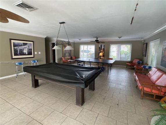 Room with a billiards table and a ping-pong table, featuring seating and decor.