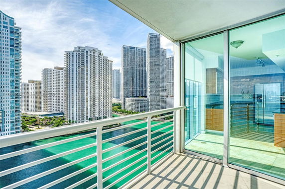 Scenic view from a balcony overlooking a city skyline with tall buildings and waterways.