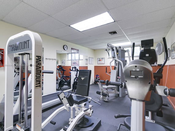 Room equipped with various gym machines and exercise equipment.