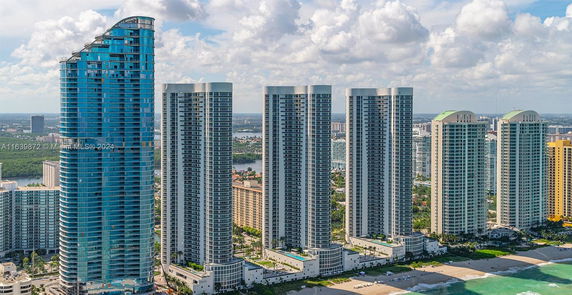 Aerial view of multiple modern high-rise buildings near a beach.