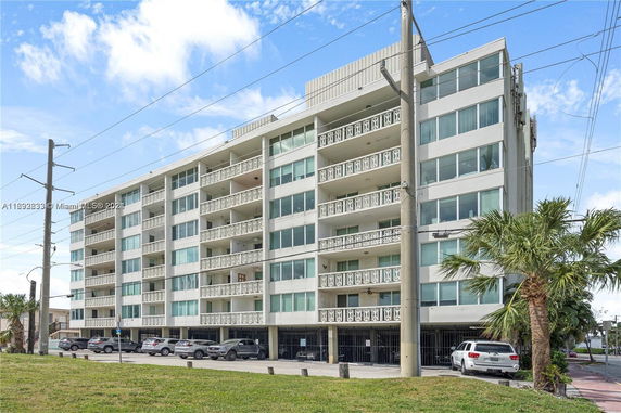Front view of a multi-story apartment building with balconies.
