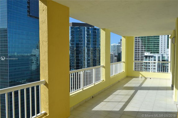 Covered balcony with a panoramic view of city skyscrapers.