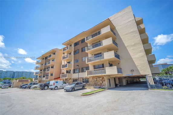 Front view of a multi-story apartment building with balconies.