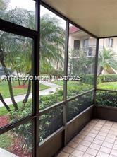 View from a screened patio overlooking garden and walkway.