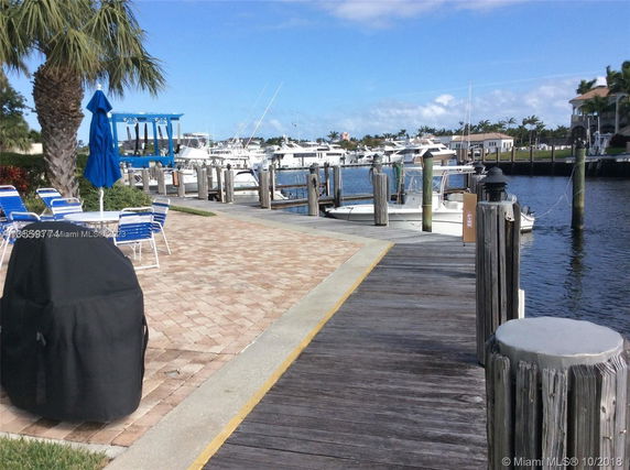 View from a dock with boats and seating areas, near a waterway.