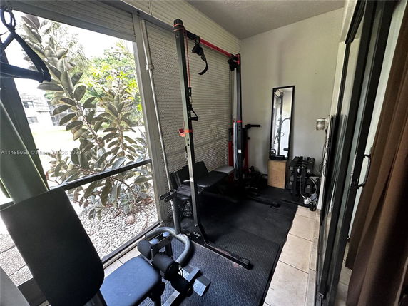 Indoor space equipped with exercise equipment including a bench and weights.