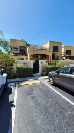 Front view of a two-story house with a tiled roof and an entrance gate.