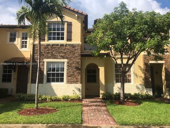 Front view of a two-story house with stone accents and an arched entryway.