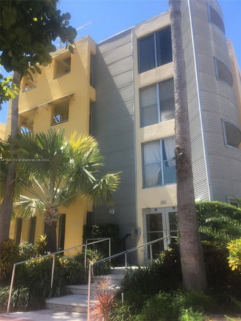 Front view of a multi-story building with yellow and gray colors.