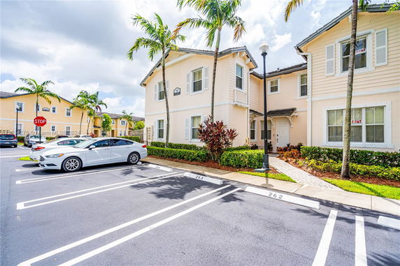 Parking area in front of a residential building with multiple units.