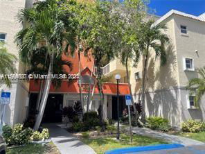 Front view of a multi-story residential building with palm trees.