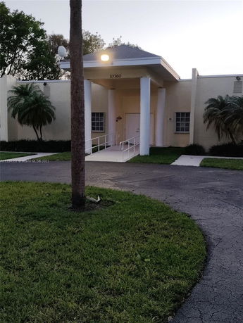 Front view of a single-story building with columns and a ramp.