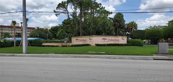 Front view of a multi-story building with a sign for Poinciana Country Club.