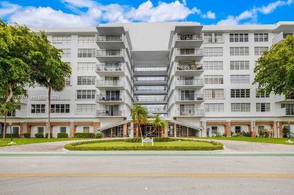 Front view of a multi-story apartment building with balconies.