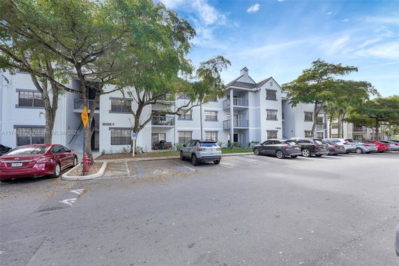 Outdoor parking area in front of a multi-story residential building.