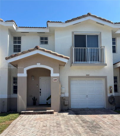 Front view of a two-story house with a single garage and balcony.