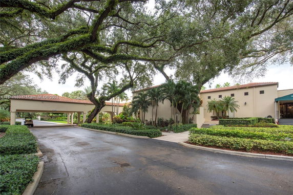 Front view of a building with a covered driveway and well-maintained landscaping.