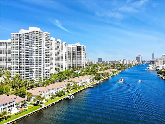 Aerial view of waterfront cityscape with high-rise buildings and river.