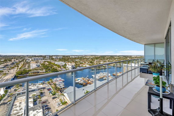 Panoramic view from a high-rise balcony overlooking the city and water.