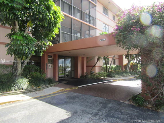 Front view of a multi-story building with an entrance covered by an overhang.