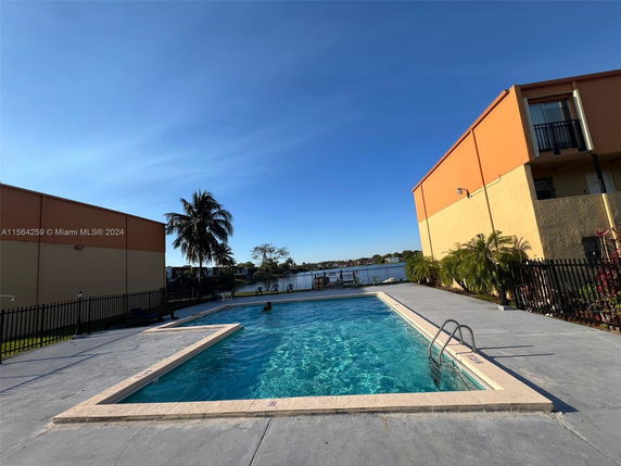 Outdoor swimming pool area with surrounding buildings.