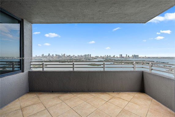 Balcony with a panoramic view of the city skyline and water.