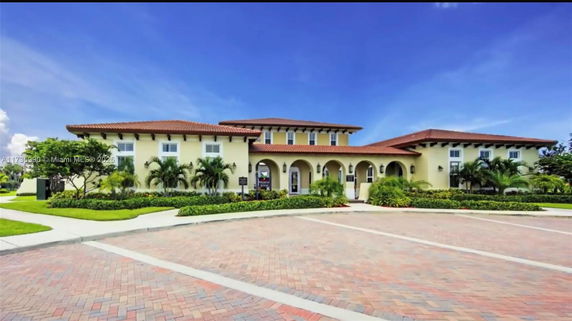Front view of a two-story building with arches and a tiled roof.
