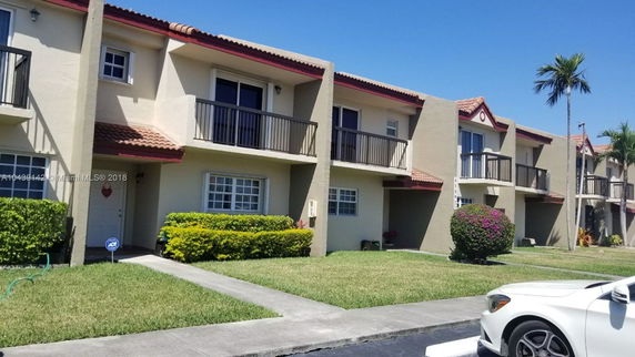 Front view of two-story residential townhouses with balconies.