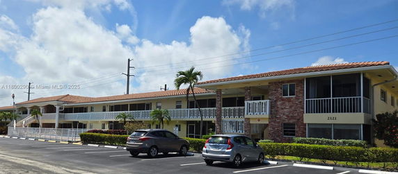 Front view of a two-story residential building with a tiled roof and balconies.