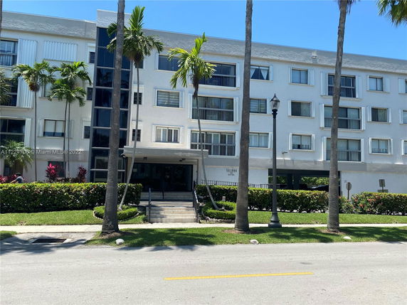 Front view of a multi-story residential building with balconies and a central entrance.