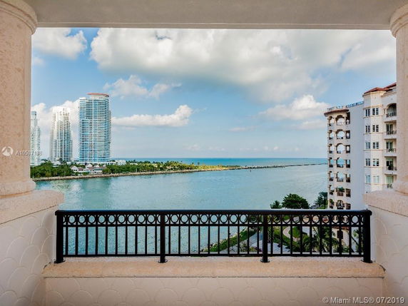 View from a balcony overlooking modern high-rise buildings by the waterfront.