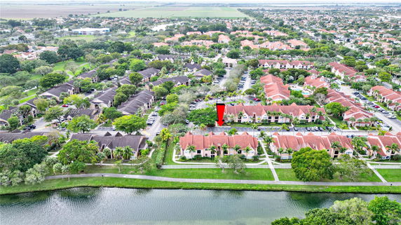 Aerial view of a residential area with several buildings, roads, and greenery.