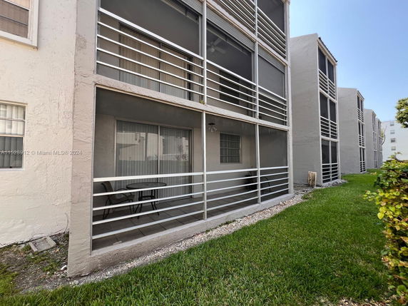 Front view of a multi-story residential building with screened balconies.
