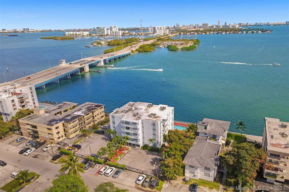Aerial view of a waterfront area with buildings, a bridge, and a body of water.