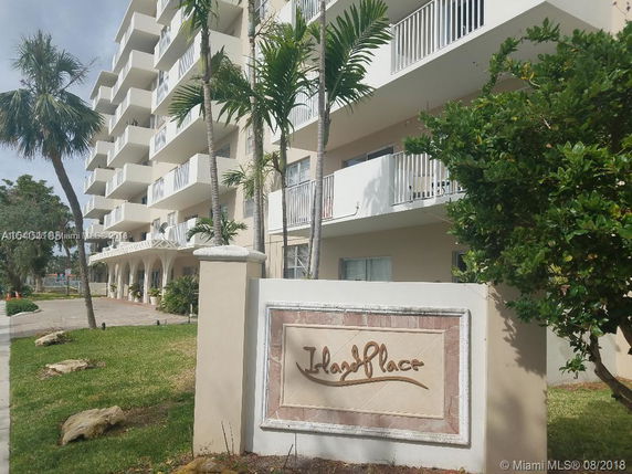 Front view of a multi-story apartment building with balconies.