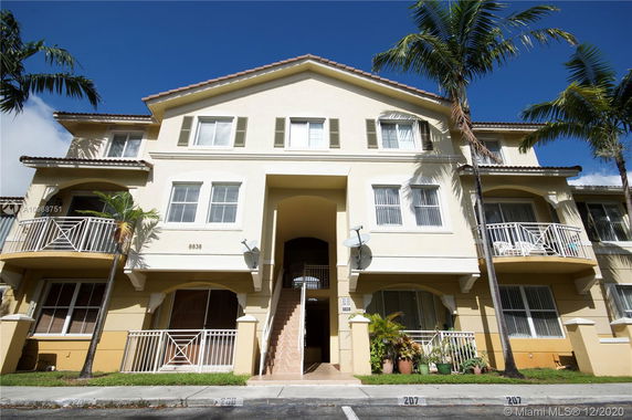 Front view of a multi-story residential building with balconies.