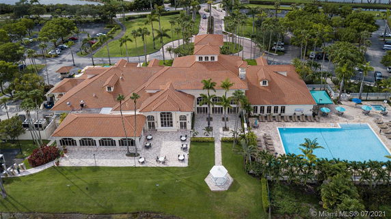Aerial view of a large building with a swimming pool and surrounding outdoor seating area.