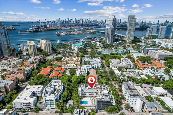 Aerial view of a coastal cityscape with numerous buildings, waterways, and a skyline in the background.