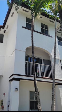 Front view of a multi-story residential building with balconies and windows.