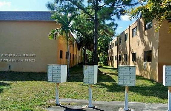 View of a two-story apartment building with multiple mailboxes in front.