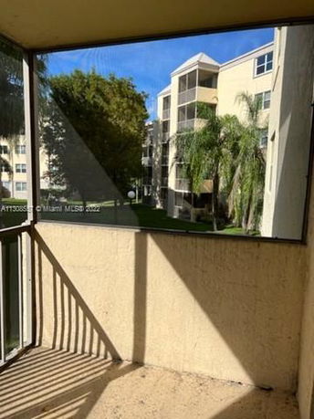 View from a balcony showing surrounding apartment buildings and trees.