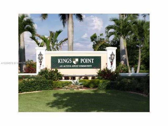 Entrance sign for King's Point with decorative columns and lanterns.